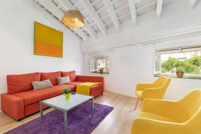 a living room with a red couch and two yellow chairs at Baron Suites Reina in Valencia