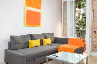 a living room with a gray couch and an orange chair at Baron Suites Reina in Valencia