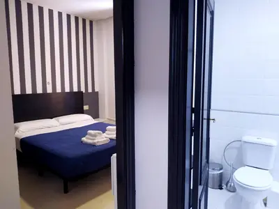 a bedroom with a blue bed and a toilet at Flats Friends Plaza de la Reina in Valencia