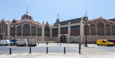 a large building with cars parked in front of it at Poeta Llombart Apartment in Valencia