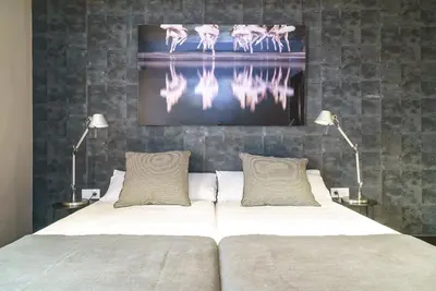 a bedroom with a bed with two lamps and a picture of flamingos at Valencia Luxury - Boutique Paz in Valencia