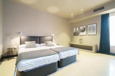 a bedroom with a large bed with blue curtains at Valencia Luxury - Boutique Paz in Valencia