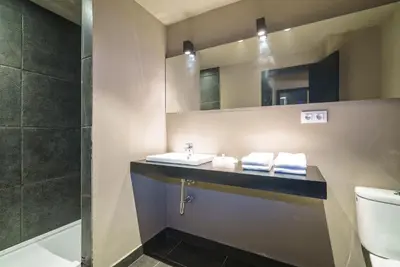 a bathroom with a sink and a toilet and a mirror at Valencia Luxury - Boutique Paz in Valencia