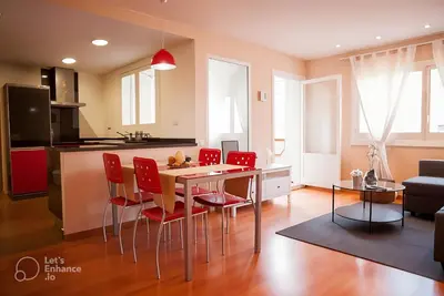 a kitchen with a dining table and red chairs at Apartamento Alameda in Valencia