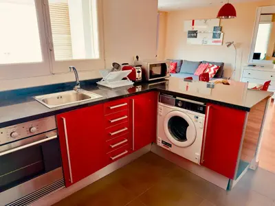 a kitchen with red cabinets and a washing machine at Apartamento Alameda in Valencia