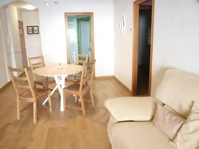 a living room with a table and chairs and a couch at ApartUP Patacona Beach I in Valencia