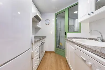 a kitchen with a sink and a green door at ApartUP Patacona Beach I in Valencia