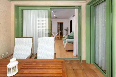 a living room with green walls and a table and chairs at ApartUP Patacona Beach I in Valencia