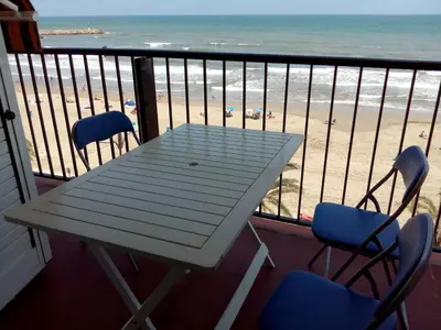 a table and chairs on a balcony with a view of the beach at Valencia Port Saplaya in Port Saplaya