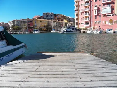a dock with boats in the water next to buildings at Valencia Port Saplaya in Port Saplaya