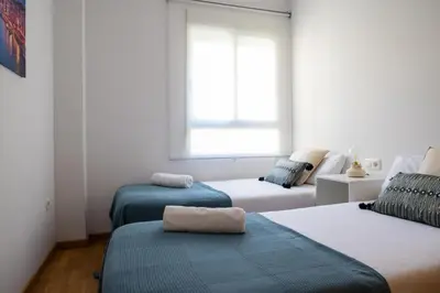 a white room with three beds and a window at Medinaceli airco, wifi and free parking in Valencia
