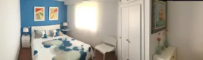 a bedroom with a bed with a blue and white comforter at Apartamento PuigVal in El Puig
