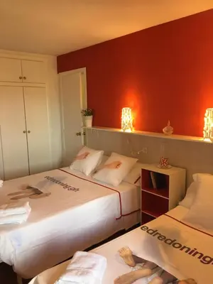 two beds in a room with red walls at Apartamento PuigVal in El Puig