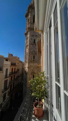 a window with a plant on a balcony with a tower at Hotel El Siglo in Valencia