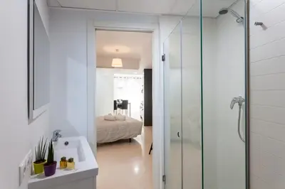 a bathroom with a glass shower and a bedroom at My Loft 4 You Na Jordana in Valencia