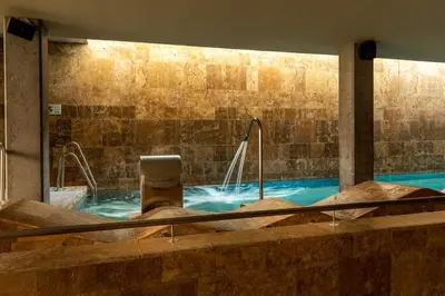 a large swimming pool with a chair in the water at Parador de El Saler in El Saler