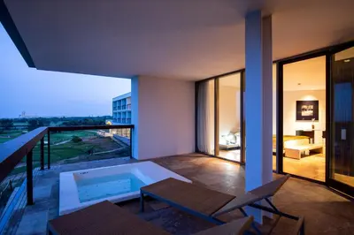 a balcony with a swimming pool and a room at Parador de El Saler in El Saler