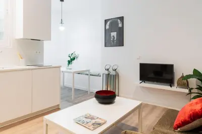 a white living room with a table and a tv at Victoria Site-Luxury Center in Valencia