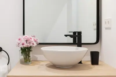 a bathroom with a sink and a vase with flowers at Victoria Site-Luxury Center in Valencia