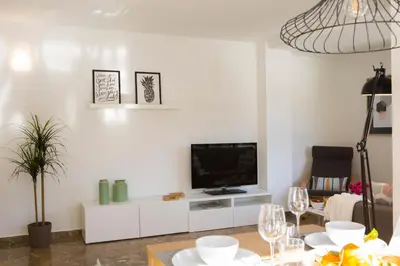 a living room with a tv on a white cabinet at Xativa Terrace II in Valencia