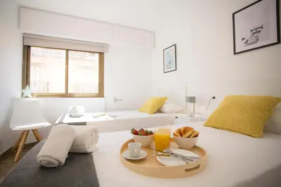 a white living room with a table with a tray of food at Xativa Terrace II in Valencia