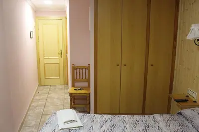 a bedroom with a bed and a table and a chair at La Posá in Villar del Arzobispo