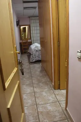 a hallway with a door and a room with a bed at La Posá in Villar del Arzobispo