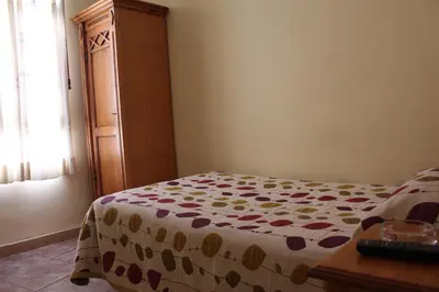 a bedroom with a bed and a wooden dresser at La Posá in Villar del Arzobispo