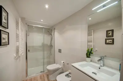 a white kitchen with a sink and a refrigerator at Beds & Breaks Casals in Valencia