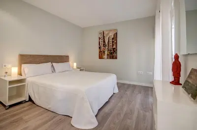 a white bedroom with a large bed with white sheets at Beds & Breaks Casals in Valencia
