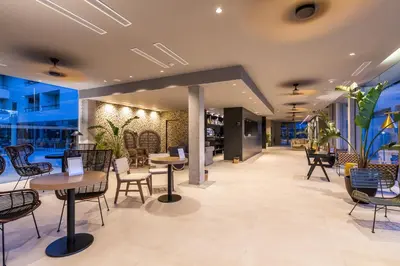 a restaurant with tables and chairs in a lobby at Hotel Barú in Sagunto