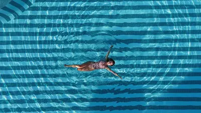 a man swimming in a pool of water at Hotel Barú in Sagunto