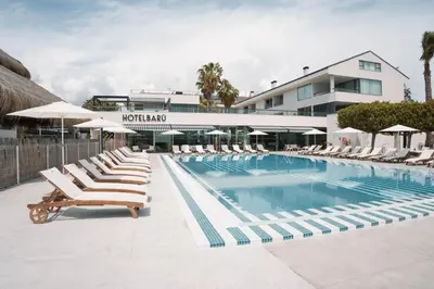 a swimming pool with lounge chairs and a hotel at Hotel Barú in Sagunto