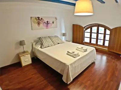a bedroom with a large bed with a wooden floor at Living Valencia Peydro in Valencia