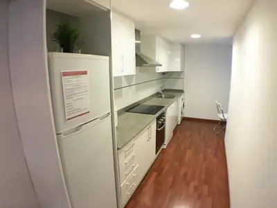 a kitchen with white appliances and a wooden floor at Living Valencia Peydro in Valencia