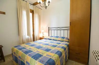 a bedroom with a bed with a blue and yellow quilt at Casa rural Vista Alegre , cerca de Valencia y Castellón in Caudiel