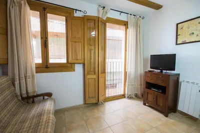 a living room with a tv and some windows at Casa rural Vista Alegre , cerca de Valencia y Castellón in Caudiel