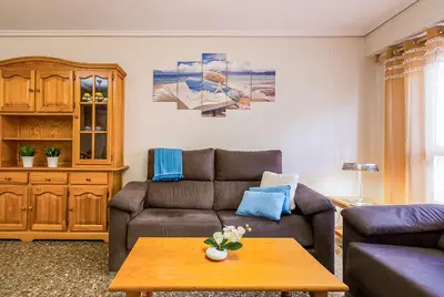 a living room with a couch and a table at MoYma Playa in Puerto de Sagunto