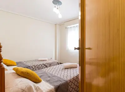 a bedroom with two beds with yellow pillows on them at MoYma Playa in Puerto de Sagunto