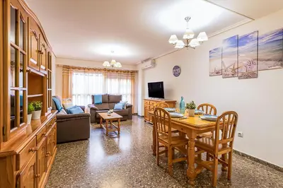a living room with a table and a dining room at MoYma Playa in Puerto de Sagunto