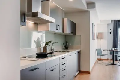 a kitchen with white cabinets and a sink and a table at Parker The Urban Flats in Valencia