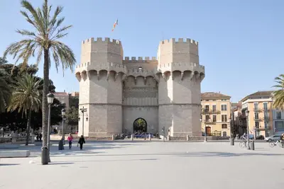 a large white building with a palm tree in front of it at Travel Habitat Torres de Serrano in Valencia