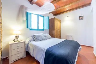 a bedroom with a bed with blue sheets and a window at Villa Rotonda in Alquerías del Niño Perdido
