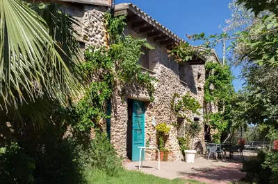 a stone house with a blue door on the side of it at Villa Rotonda in Alquerías del Niño Perdido
