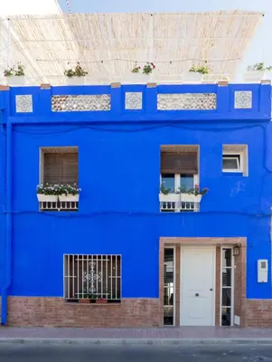a blue building with two windows and a white door at La Casa Azul in Alquerías del Niño Perdido