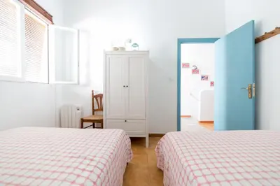 a bedroom with two beds and a white cabinet at La Casa Azul in Alquerías del Niño Perdido