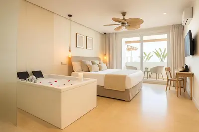 a bedroom with a bed and a tub in a room at Meraki Beach Hotel - Only Adults in Playa Pobla de Farnals