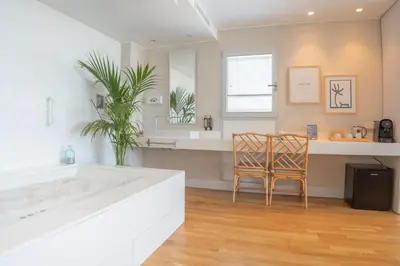 a bathroom with a tub and a table and a chair at Meraki Beach Hotel - Only Adults in Playa Pobla de Farnals