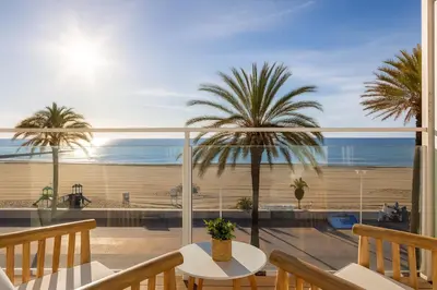 a balcony with a view of the ocean and palm trees at Meraki Beach Hotel - Only Adults in Playa Pobla de Farnals