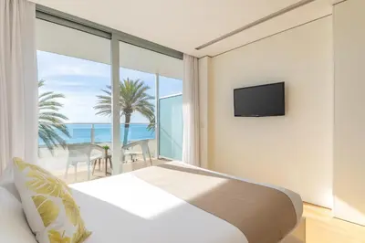 a bedroom with a bed and a view of the ocean at Meraki Beach Hotel - Only Adults in Playa Pobla de Farnals